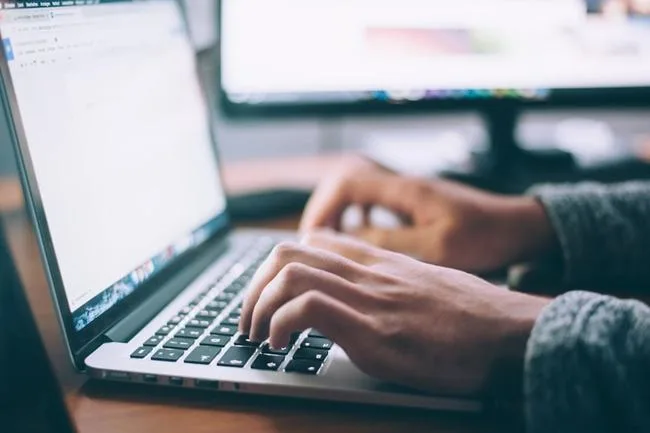 An employee accesses a company knowledge management system before completing a task